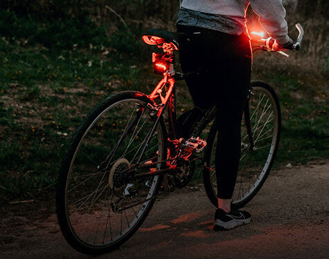 person standing over a bike with two guardian angel lights mounted to it