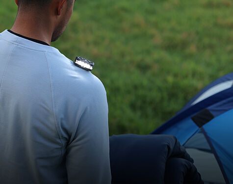 person standing in front of a tent with a guardian angel device on their shoulder