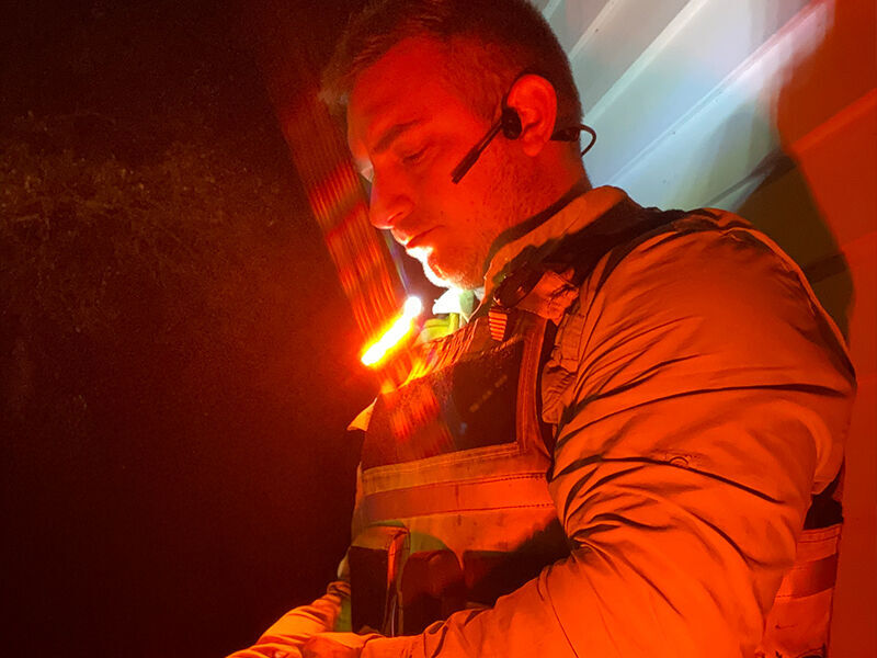person leaning against a wall with guardian angel light mounted to their shoulder