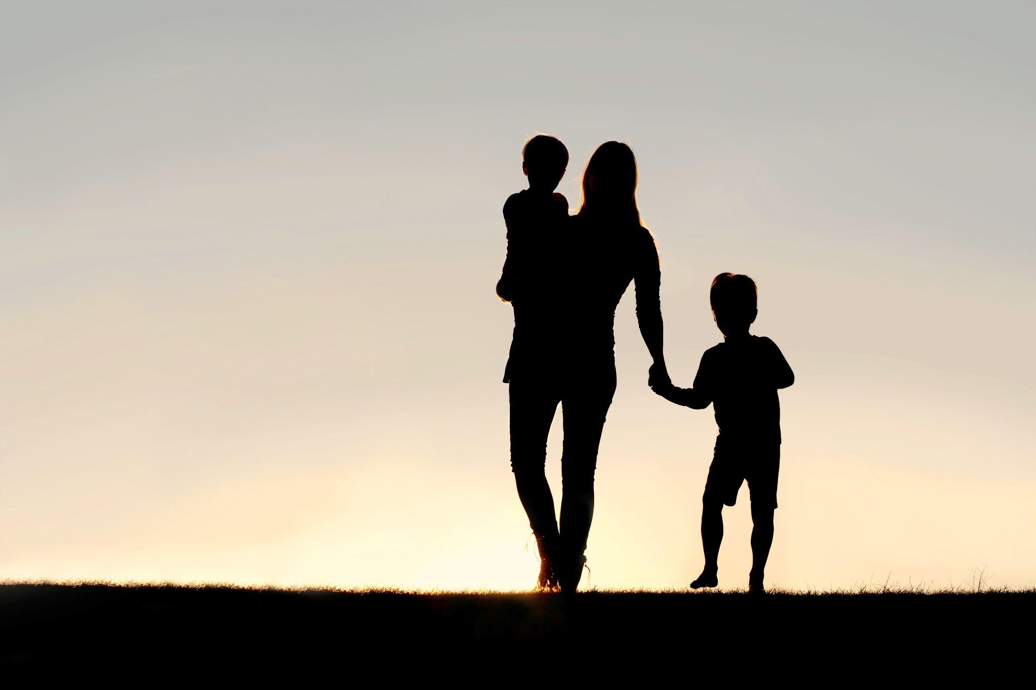 Children and parents silhouetted as they walk at dusk